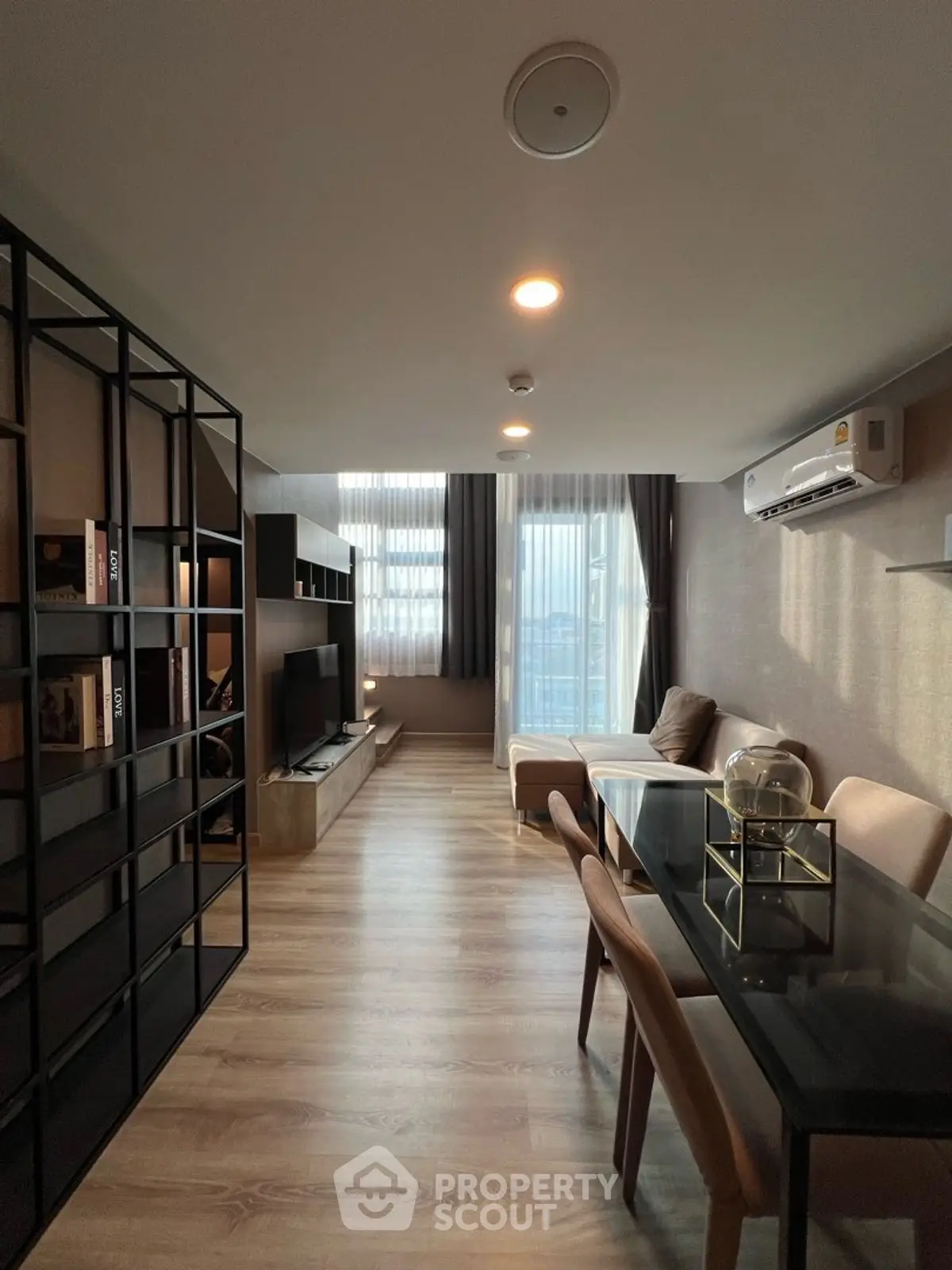 Modern living room with sleek furniture and large windows offering natural light.