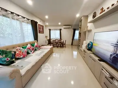 Spacious living room with modern decor and large TV, perfect for family gatherings.