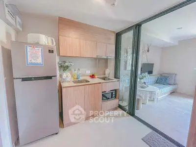 Modern open-layout kitchen with sleek appliances and cozy living area in stylish apartment.