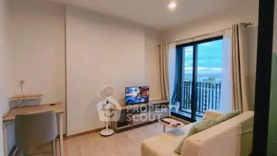 Modern living room with balcony view, cozy sofa, and entertainment setup in a stylish apartment.