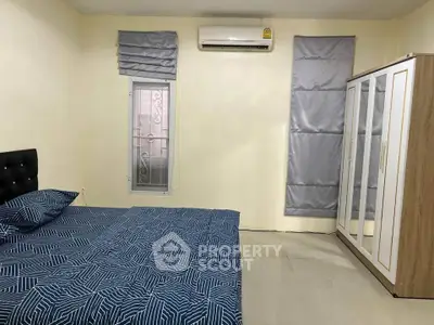 Cozy bedroom with modern decor, featuring a comfortable bed, air conditioning, and ample wardrobe space.