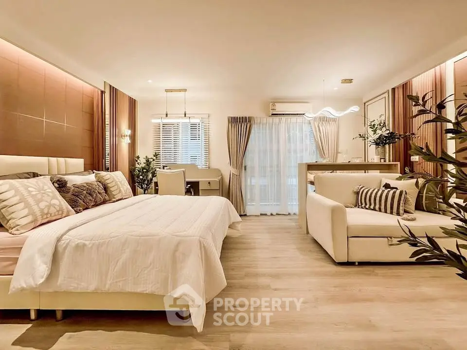 Luxurious open-plan bedroom with elegant decor and cozy seating area.