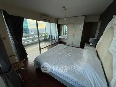 Spacious bedroom with balcony and city view in modern apartment