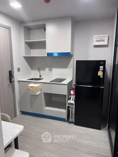 Modern compact kitchen with sleek appliances and minimalist design in a stylish apartment.