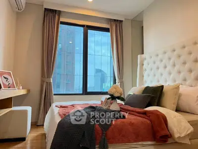 Luxurious bedroom with city view, plush bedding, and elegant decor in modern apartment.
