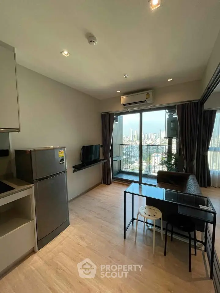 Modern living room with balcony view in high-rise apartment, featuring sleek furniture and natural light.