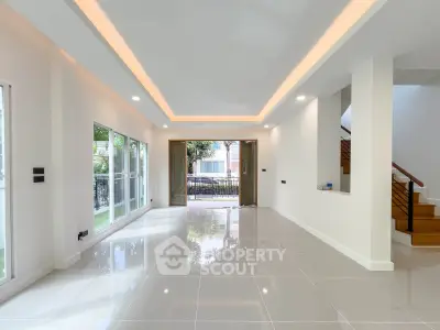 Spacious modern living room with large windows and sleek tile flooring
