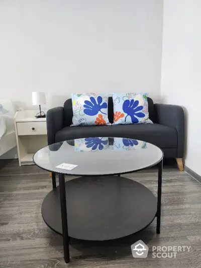 Modern living room with stylish sofa and glass coffee table, perfect for cozy relaxation.