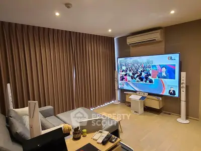 Modern living room with large TV, cozy sofa, and elegant decor, perfect for entertainment and relaxation.