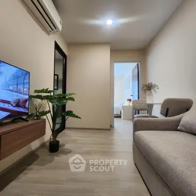 Modern living room with cozy sofa, wall-mounted TV, and air conditioning in a stylish apartment.