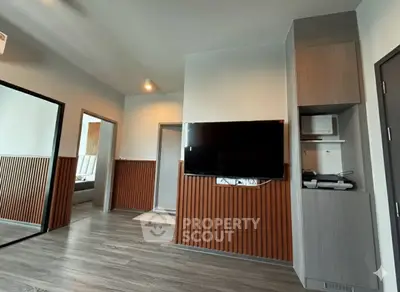Modern living room with sleek TV setup and stylish wood paneling