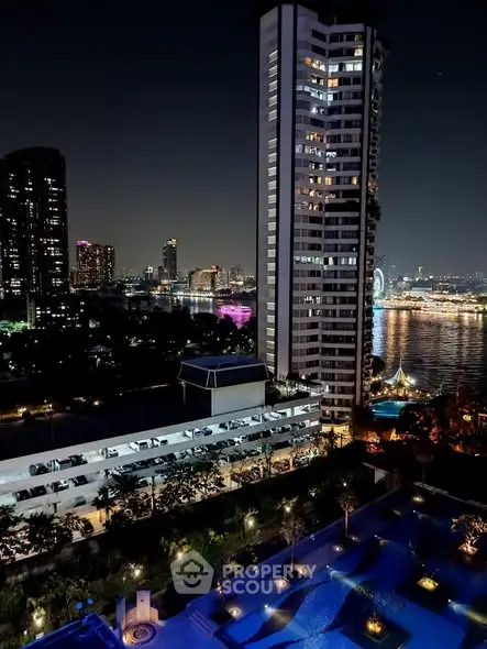 Stunning night view of cityscape with illuminated high-rise buildings and riverfront pool area.