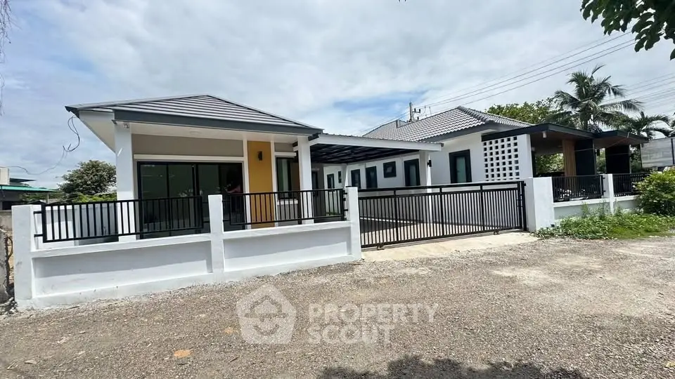 Modern single-story house with spacious driveway and sleek fence design.