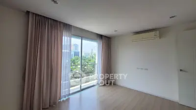 Spacious bedroom with balcony and air conditioning in modern apartment
