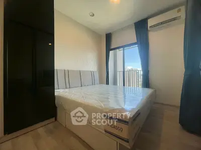 Modern bedroom with large window and air conditioning in a stylish apartment.