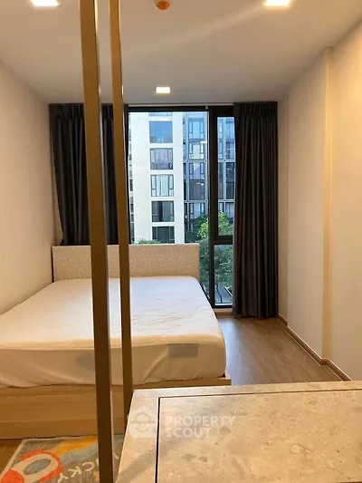 Modern bedroom with large window and city view in a stylish apartment