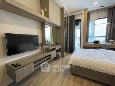 Modern bedroom with sleek furniture and large windows offering city views