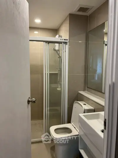 Modern bathroom with sleek shower and compact design in contemporary apartment.