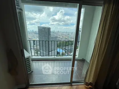 Stunning city view from a high-rise balcony with sliding glass doors.