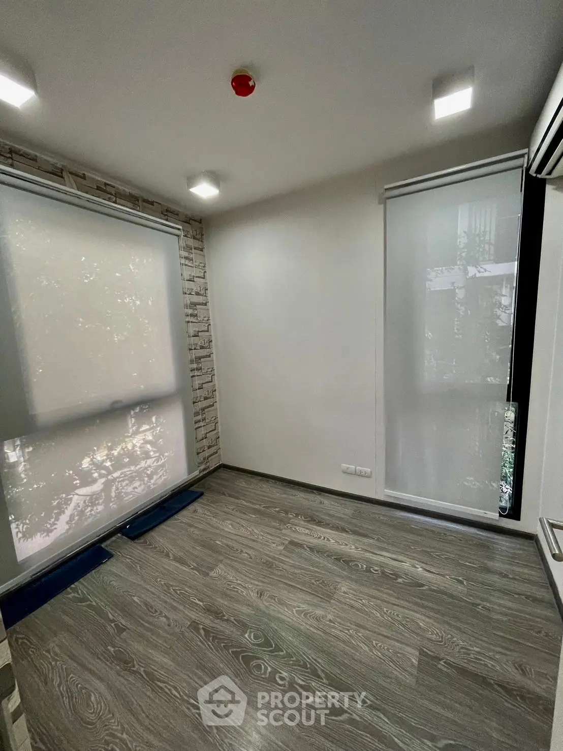 Modern unfurnished room with large windows and wood flooring, ideal for customization.