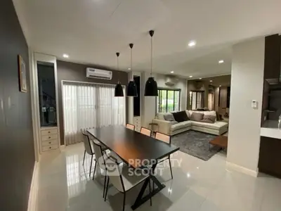 Spacious modern living and dining area with sleek furniture and natural light.