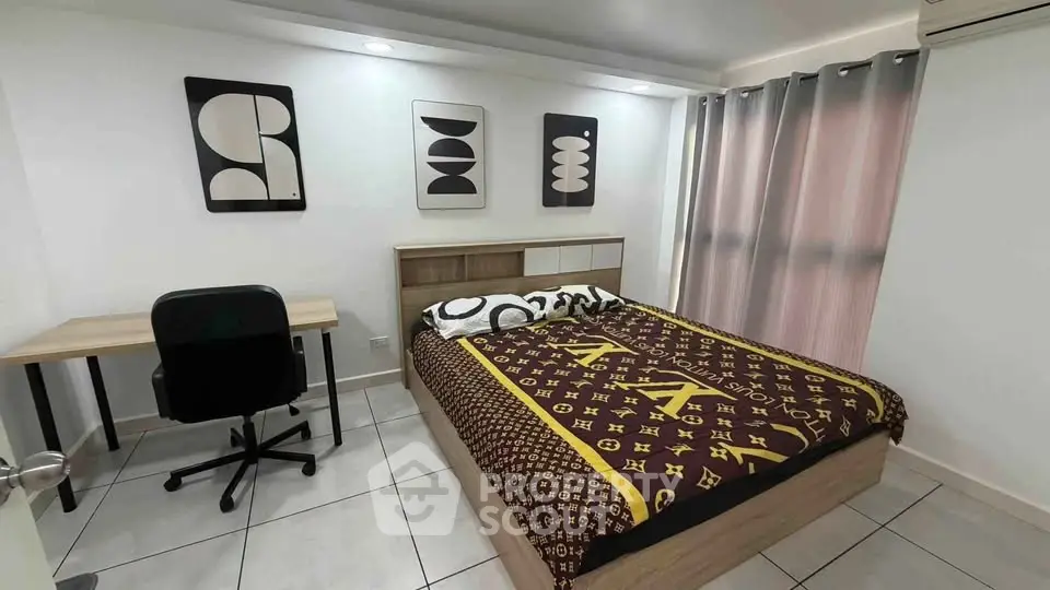 Modern bedroom with stylish decor and workspace, perfect for urban living.