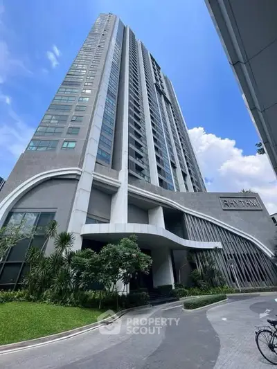 Stunning modern high-rise building with lush landscaping and sleek architectural design.