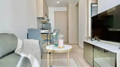 Modern living room with sleek furniture and open kitchen layout in a stylish apartment.