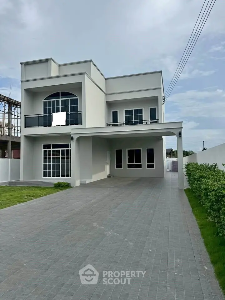 Modern two-story house with spacious driveway and lush green lawn