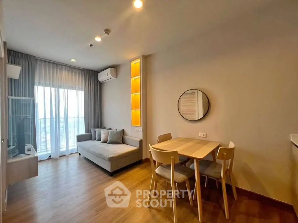 Modern living room with cozy sofa, dining table, and large window for natural light.
