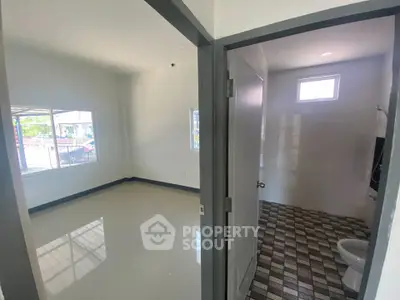 Spacious unfurnished room with adjacent tiled bathroom, ideal for customization.