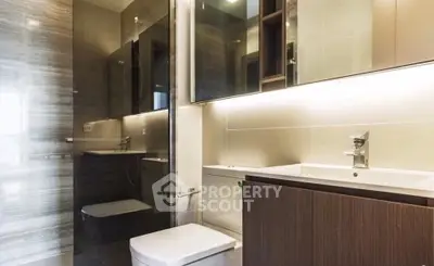 Modern bathroom with sleek fixtures and ambient lighting, featuring a stylish vanity and spacious shower area.