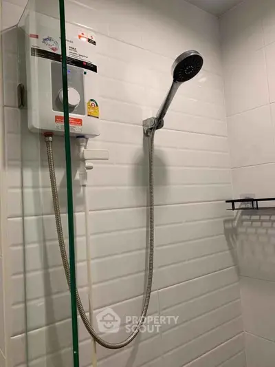 Modern bathroom with sleek showerhead and water heater in a tiled enclosure.