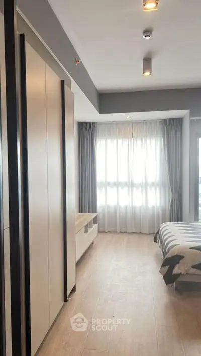 Bright and spacious bedroom with large window and modern decor