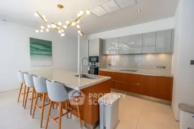 Modern kitchen with sleek cabinetry and stylish island seating in a contemporary home.