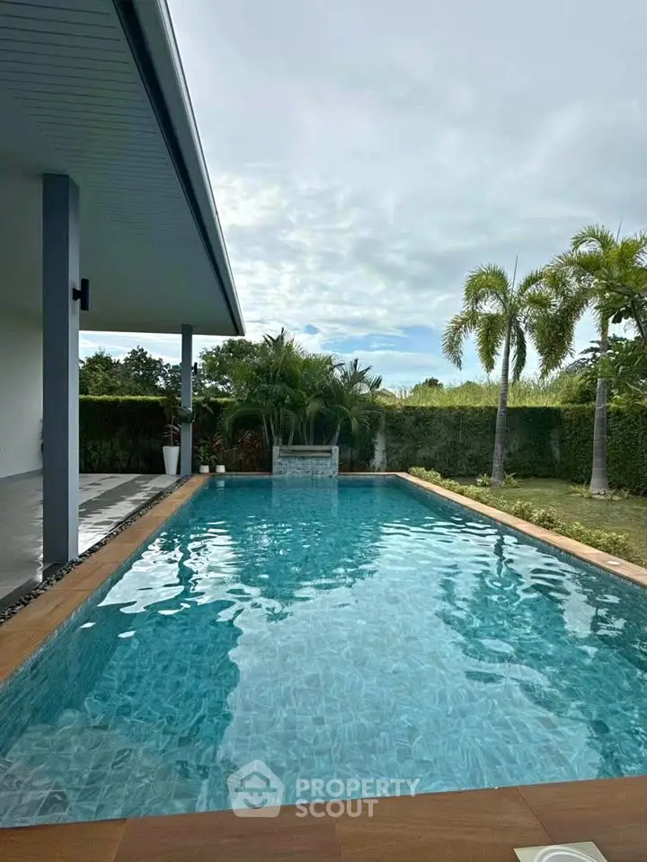 Luxurious outdoor pool with lush greenery and modern architecture, perfect for relaxation and entertainment.