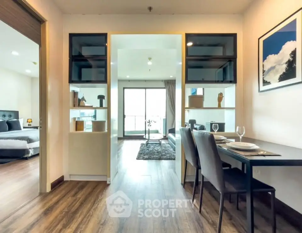 Modern open-plan apartment with stylish dining area and spacious living room, featuring elegant decor and natural light.