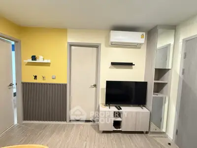 Modern living room with TV, air conditioning, and stylish decor in a cozy apartment.