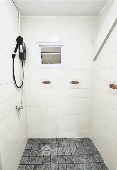 Spacious bathroom with modern shower and tiled walls, perfect for a refreshing experience.