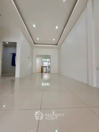 Spacious modern living room with sleek tile flooring and recessed lighting