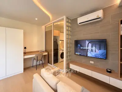 Modern living room with sleek design, featuring a cozy sofa, wall-mounted TV, and stylish workspace.