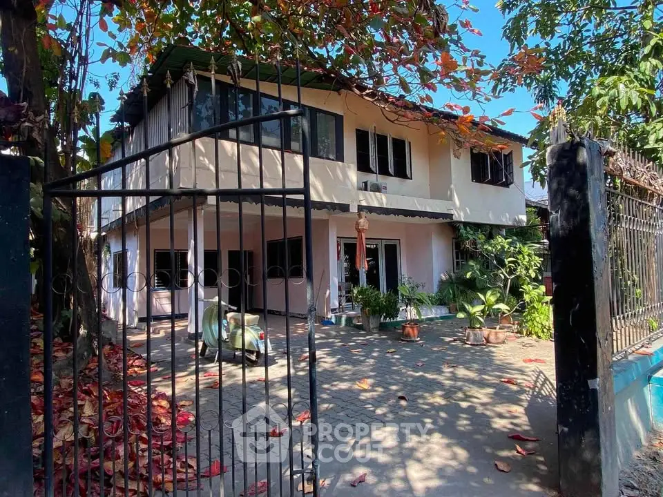 Charming two-story house with spacious front yard and lush greenery, perfect for family living.