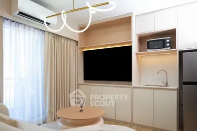 Modern living room with sleek kitchenette, featuring a microwave and stylish lighting, perfect for urban living.