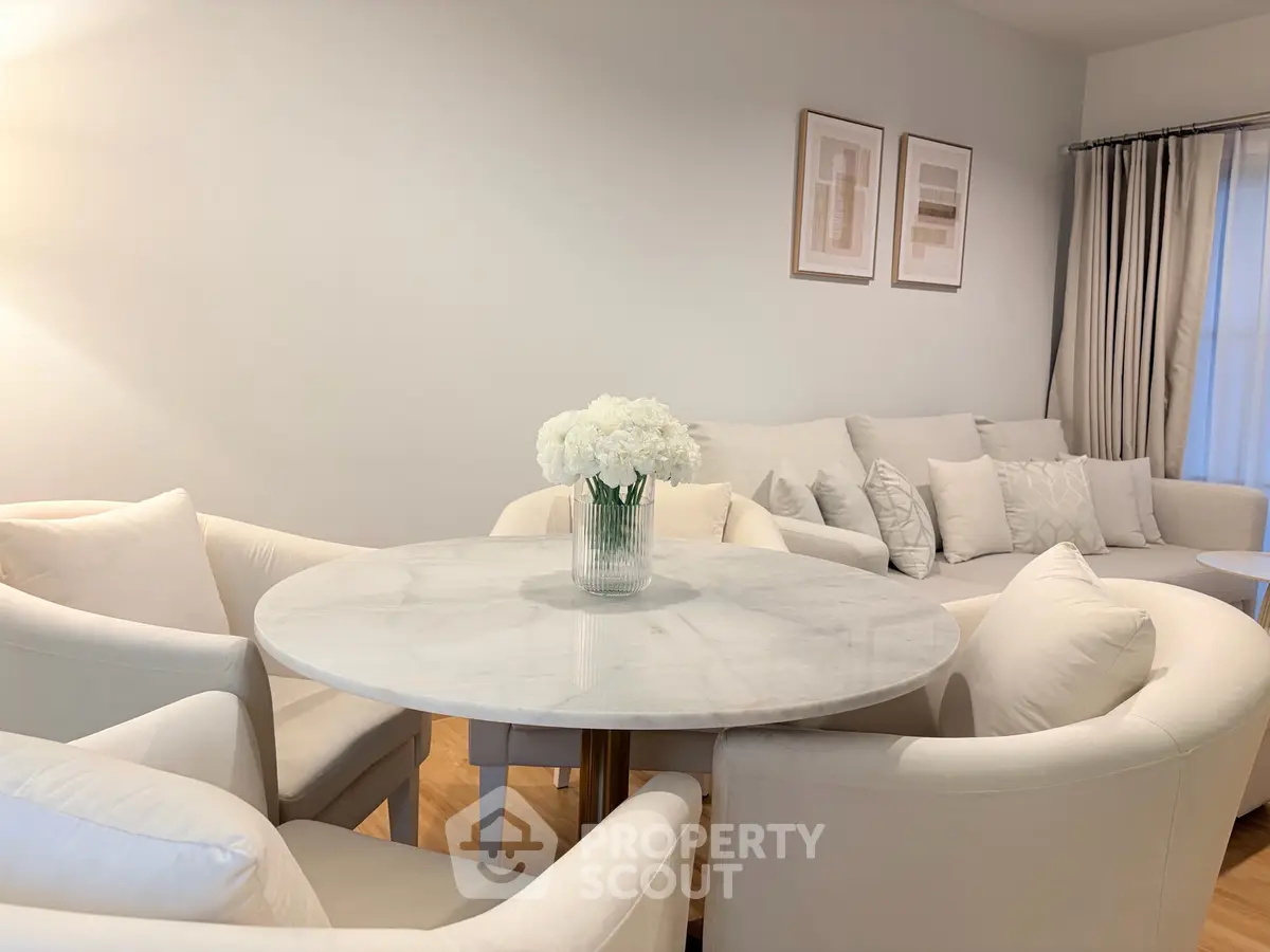 Elegant living room with white furniture and marble table, perfect for modern living.