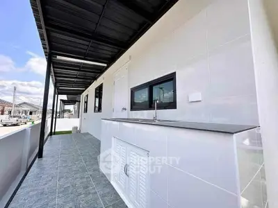 Modern balcony with sleek tiles and outdoor sink, perfect for entertaining.