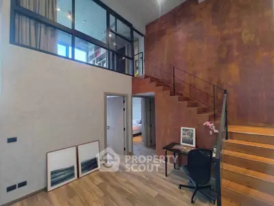 Modern loft-style interior with mezzanine, wooden floors, and stylish staircase.