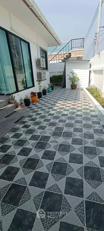 Spacious tiled balcony with potted plants and modern exterior design