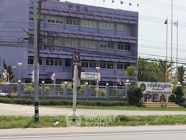 Purple government building with flags and signage on a sunny day
