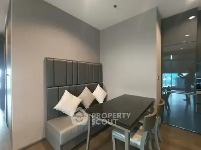 Modern dining nook with sleek table and cushioned seating in a stylish apartment.