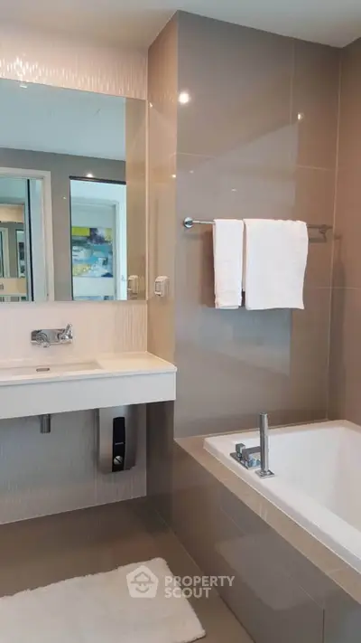 Modern bathroom with sleek design featuring a bathtub and stylish fixtures.